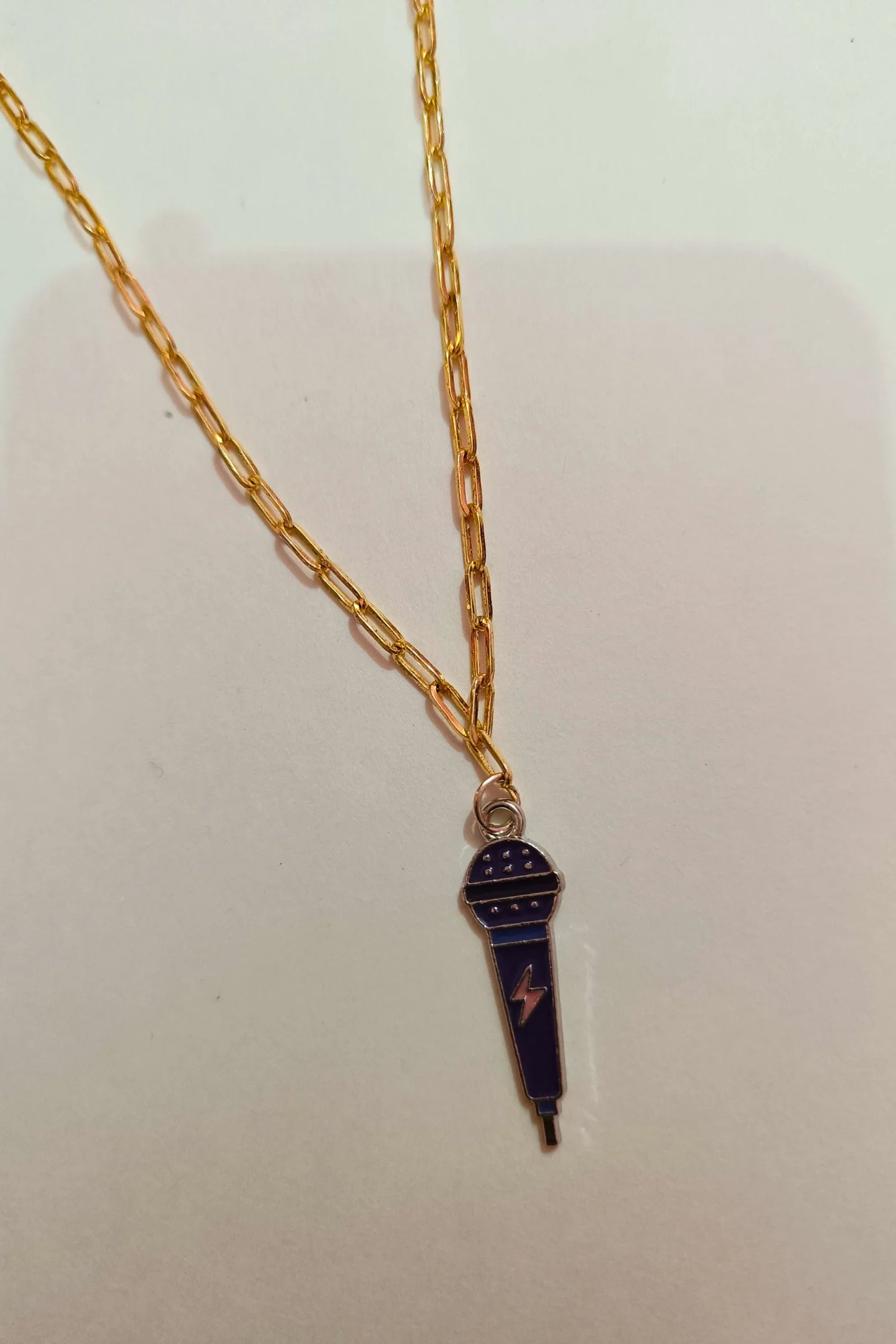 3rd view of a gold chain necklace with a small pendant shaped like a K-Pop microphone.
