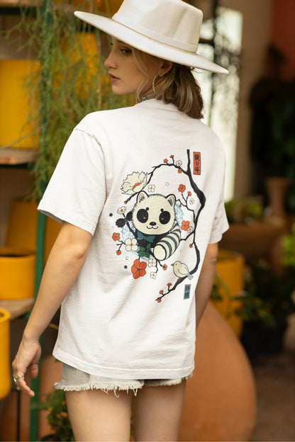 Back view of a female model wearing a off white oversized tee with a panda fox surrounded by bamboo.