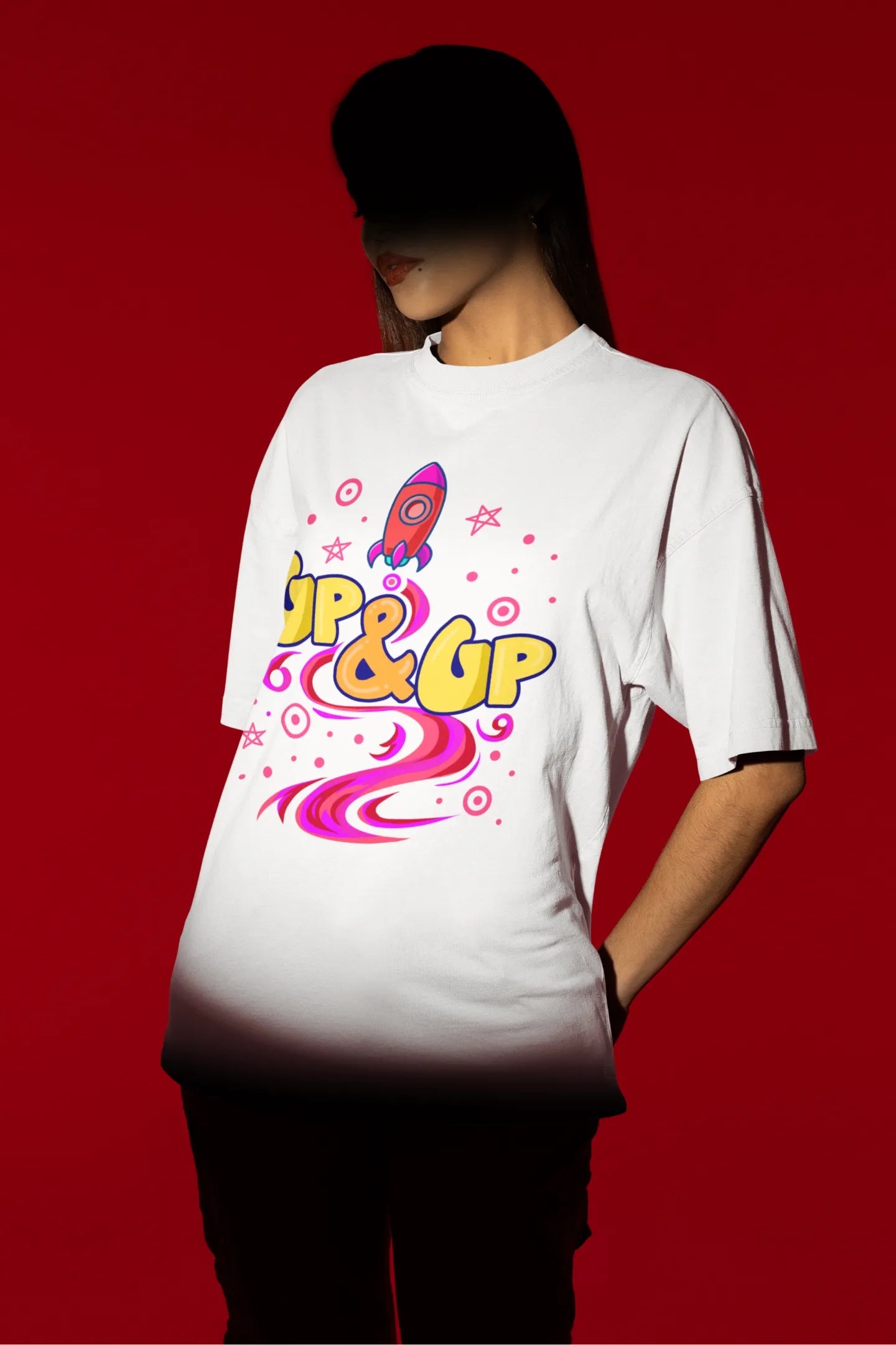 First front view of a female model wearing an off-white oversized t-shirt with a rocket ship design and the text "Up & Up".