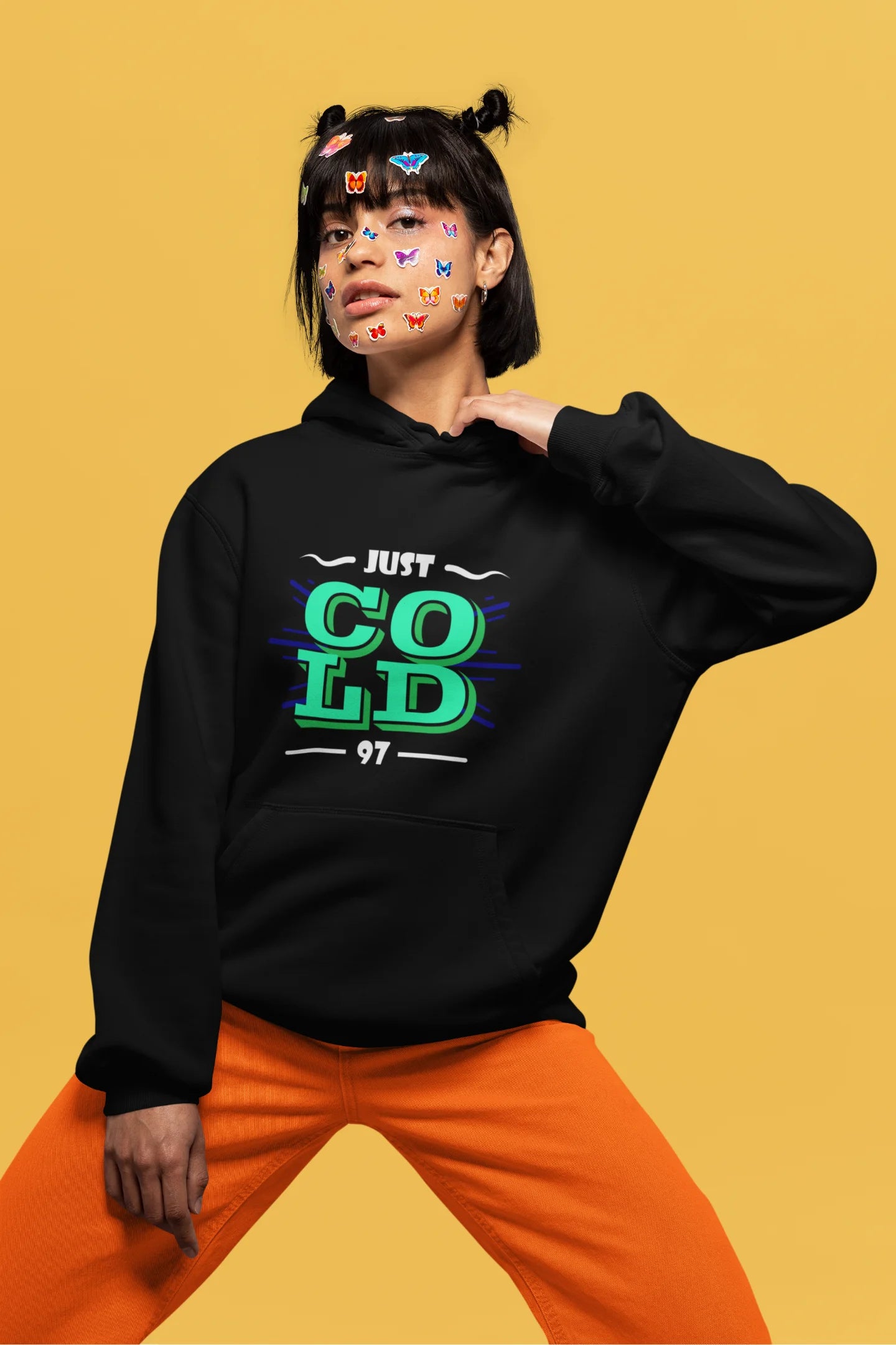 4th front view of a female model wearing an black sweatshirt with the text "Just Cold" printed on it.