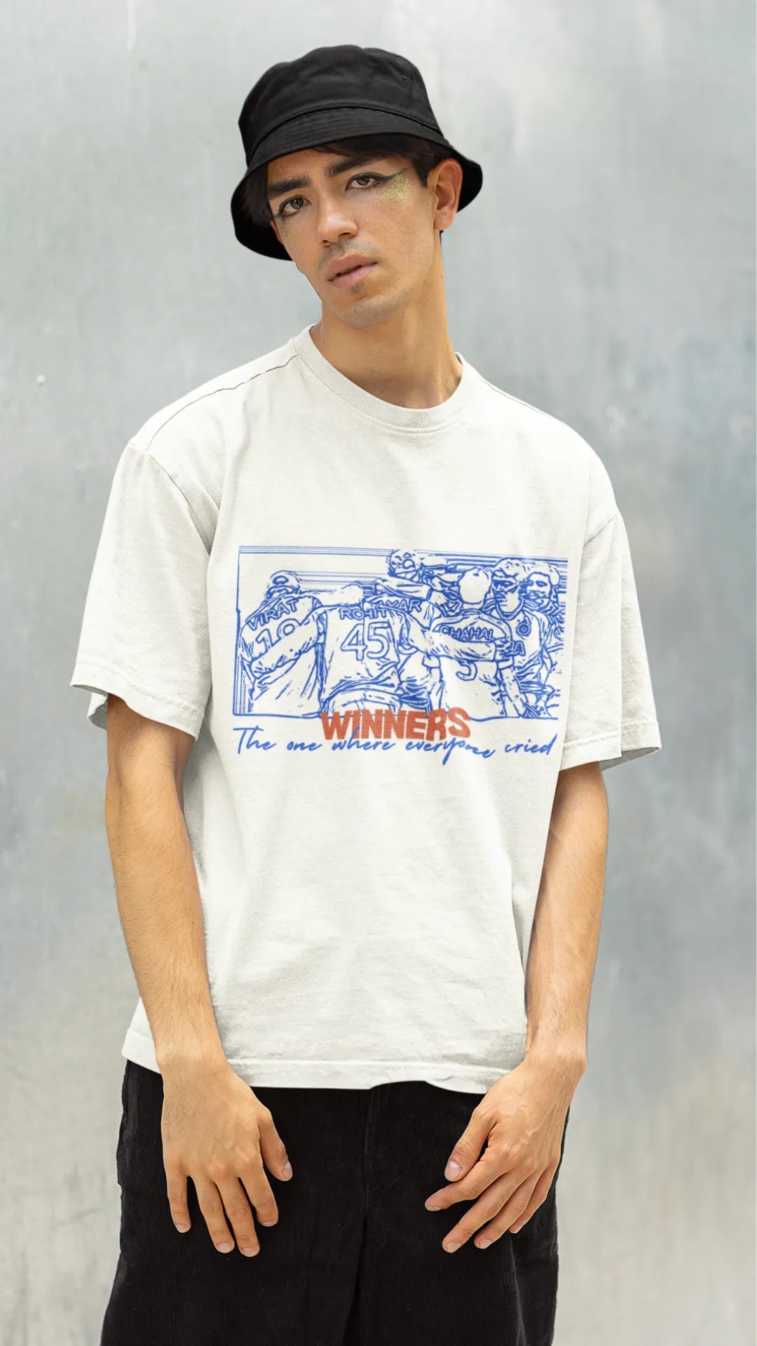 Right side view of a male model wearing an of-white oversized t-shirt featuring a design of the Indian cricket team in a celebratory huddle with the text "Winners" above them. Ideal for Indian cricket fans commemorating their team's World Cup victory.