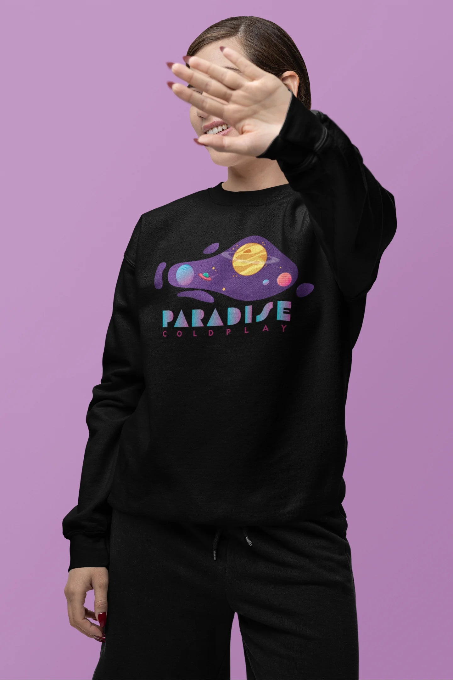 Second front view of a female model wearing an black sweatshirt with the "Paradise" album artwork by Coldplay.