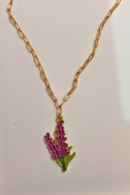 2nd view of a gold chain necklace with a small pendant shaped like a Snapdragon flower.
