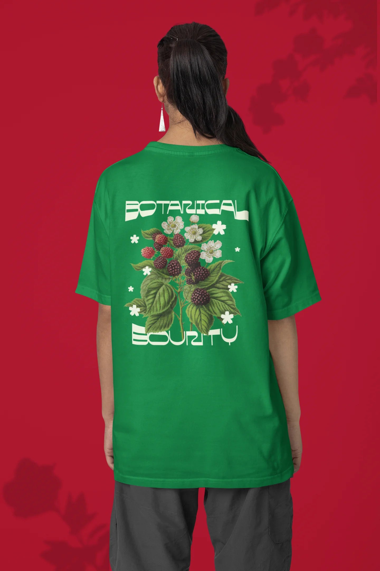 Back of a female model model wearing a forest green with a design featuring berry bushes overflowing with fruit, symbolizing the abundance and beauty of nature.