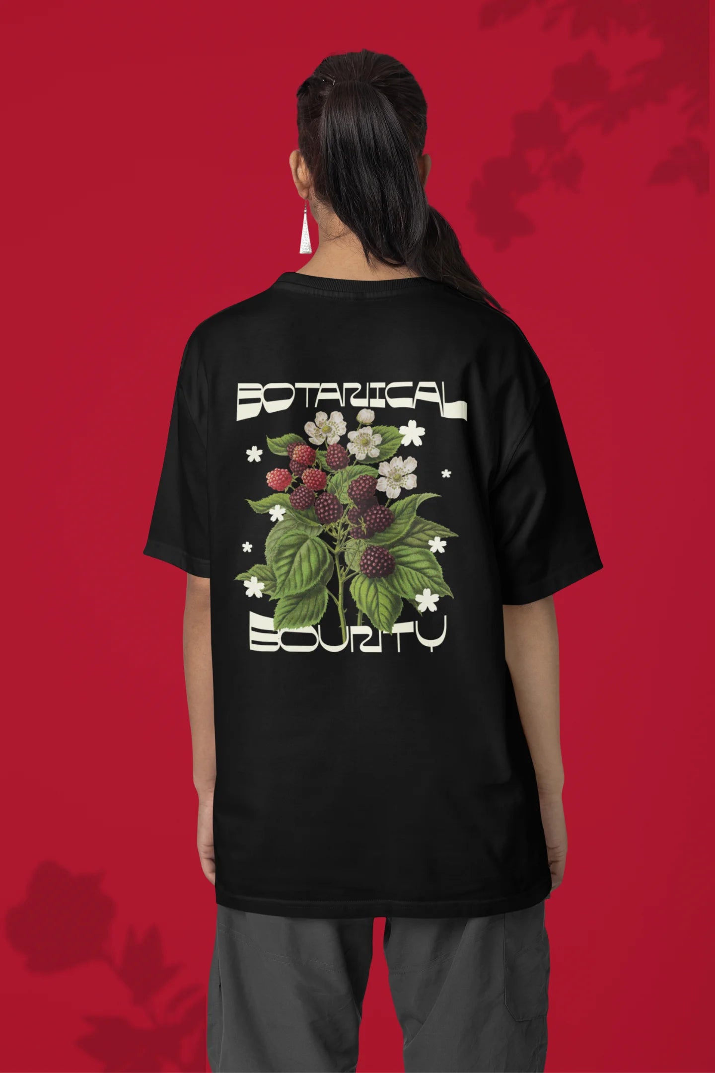 Back of a female model model wearing a black with a design featuring berry bushes overflowing with fruit, symbolizing the abundance and beauty of nature.