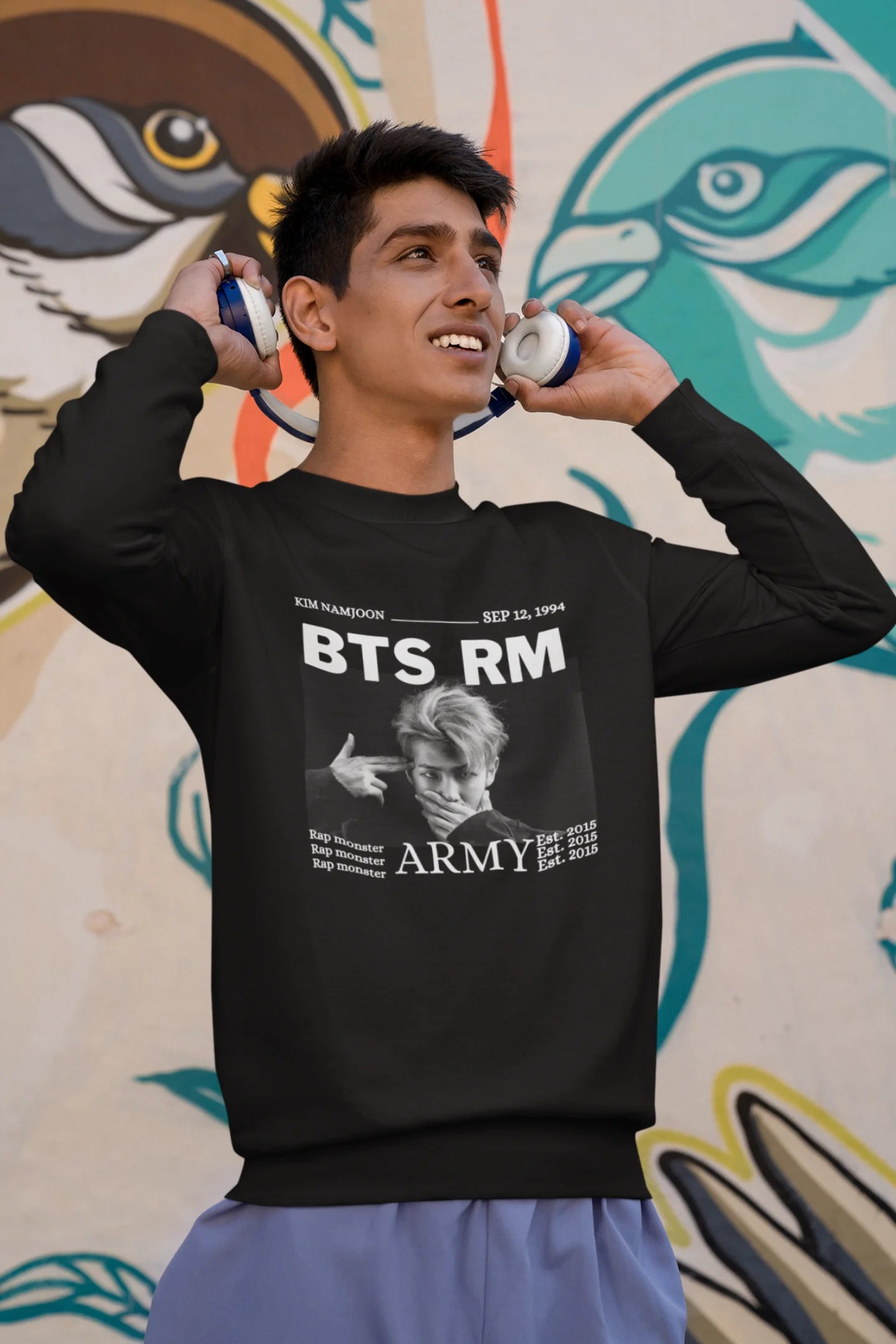 Second front view of male model wearing a black sweatshirt featuring a design representing all seven members of BTS. Ideal for BTS fans (ARMY) who want to show their love for the entire group.