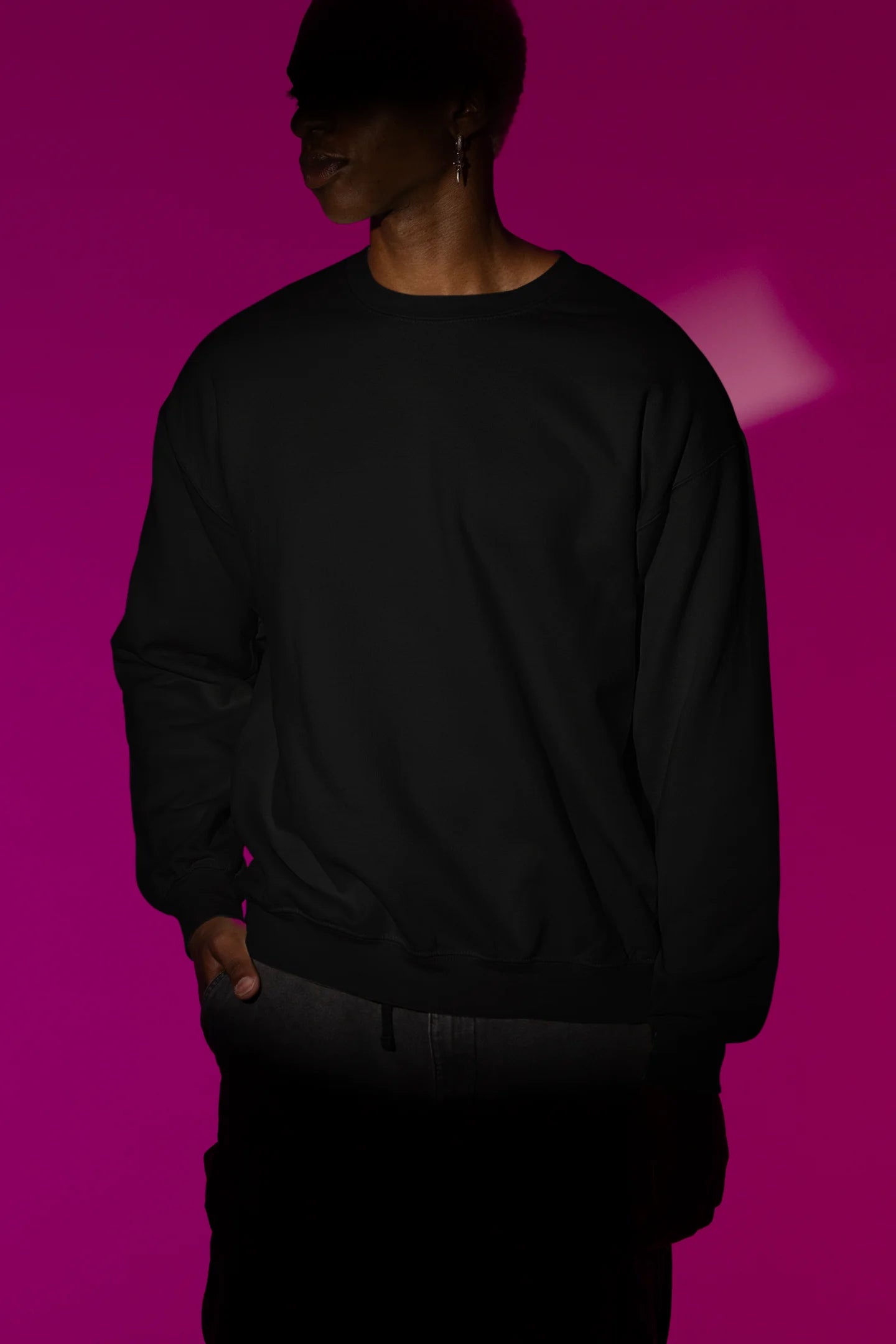 First front view of a male model wearing a black sweatshirt with a heron taking off under the moonlight.