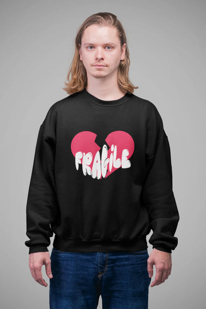 3rd front view of a male model wearing a black sweatshirt with a broken heart design and the word "Fragile" in melting text.