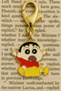 A keychain featuring a charm of Shinchan jumping in the air with the word 