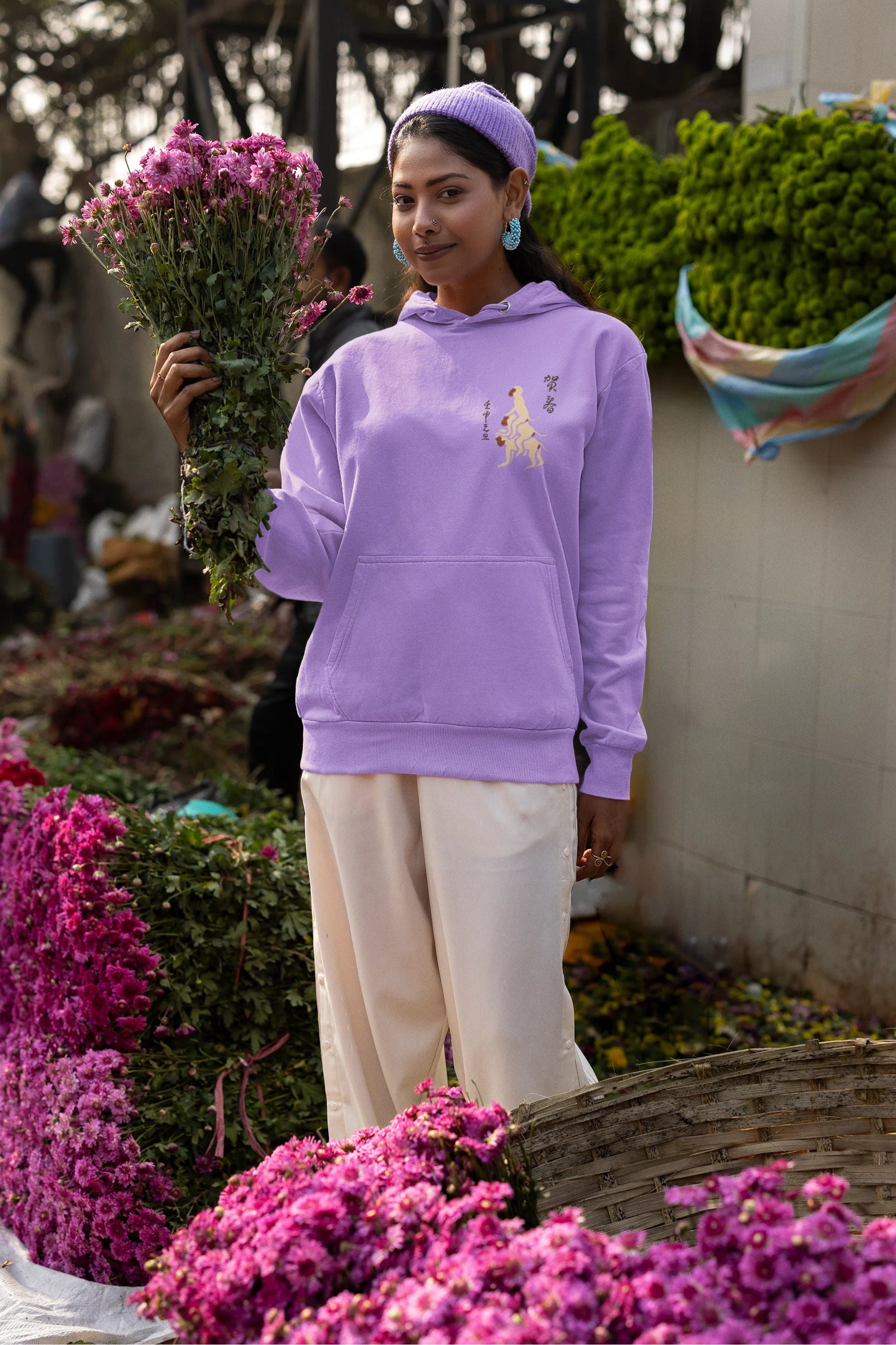 Sixth front view of a female model wearing a lavender hoodie with a design of the three wise monkeys: "See no evil, hear no evil, speak no evil."