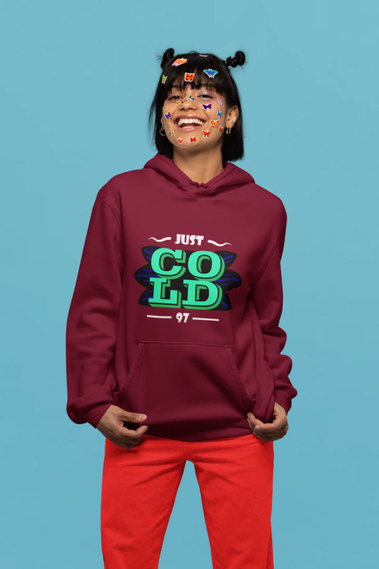First front view of a female model wearing an maroon sweatshirt with the text "Just Cold" printed on it.