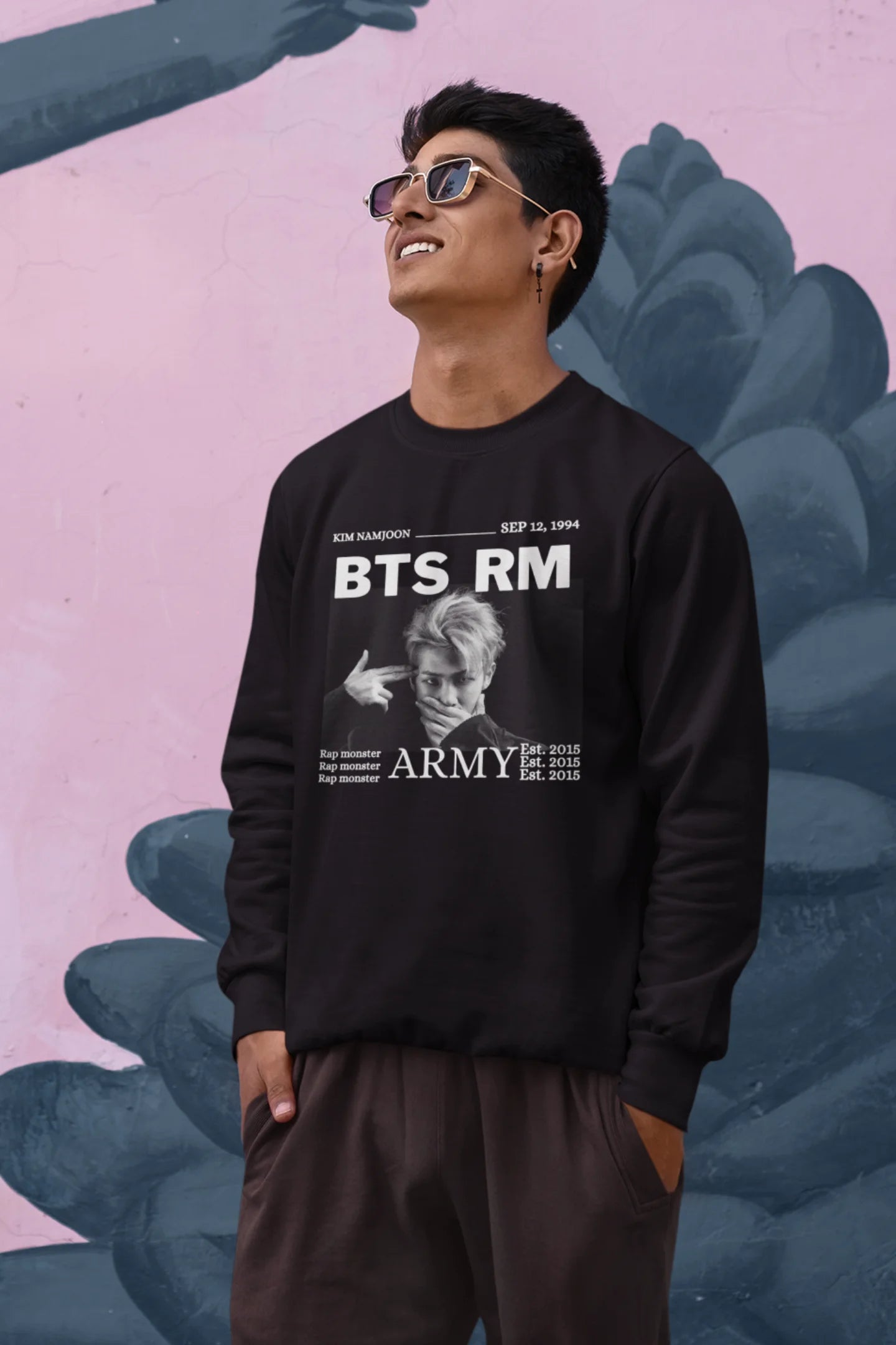 Third front view of male model wearing a black sweatshirt featuring a design representing all seven members of BTS. Ideal for BTS fans (ARMY) who want to show their love for the entire group.