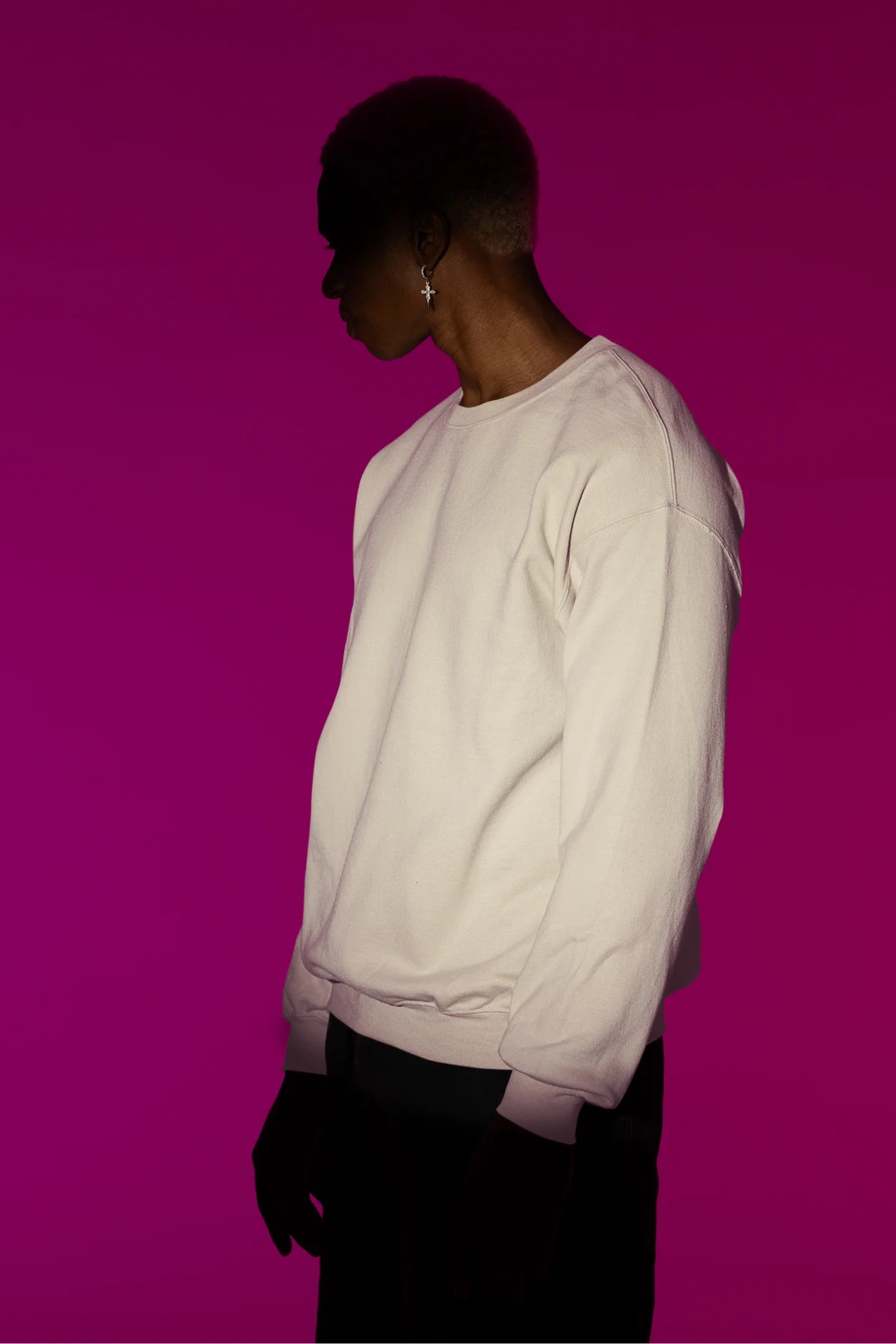 Second front view of a male model wearing a cream sweatshirt with a heron taking off under the moonlight.