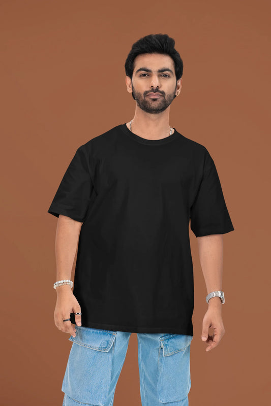 3rd front view of a male model wearing a black oversized t-shirt featuring a beach at night with a starry sky above, inspired by Ed Sheeran's "Tenerife Sea."