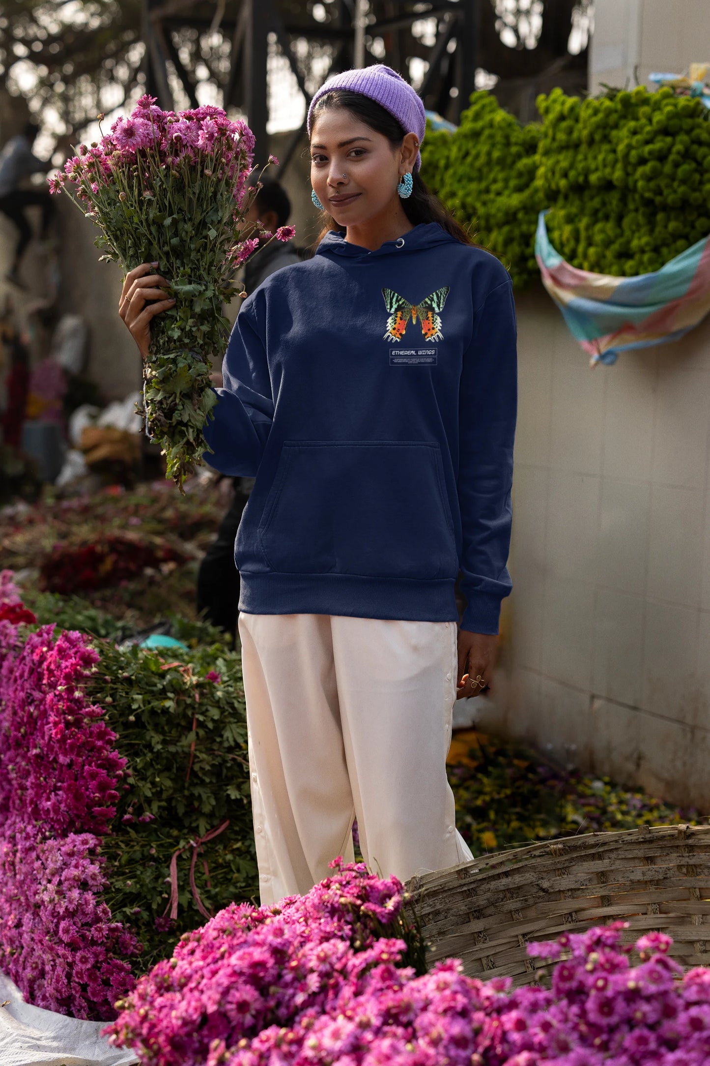 Second front view of a female model wearing a navy blue hoodie with a glowing butterfly design, symbolizing the ethereal beauty of nature.