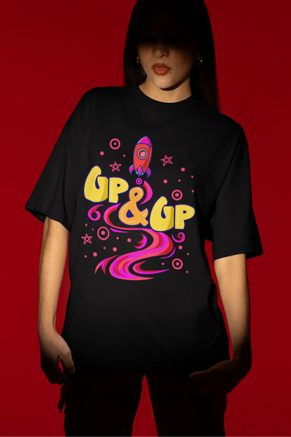 Fourth front view of a female model wearing an black oversized t-shirt with a rocket ship design and the text "Up & Up".