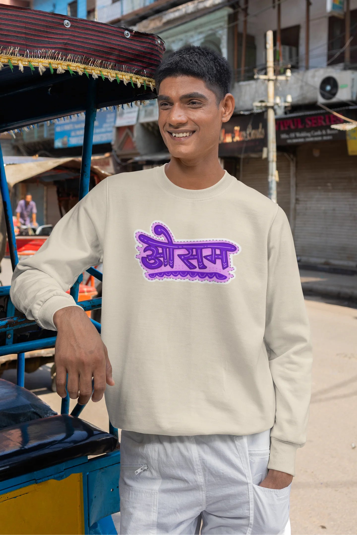 2nd front view of a male model wearing a cream colored oversized graphic t-shirt featuring the word "awesome" in a Hindi script.