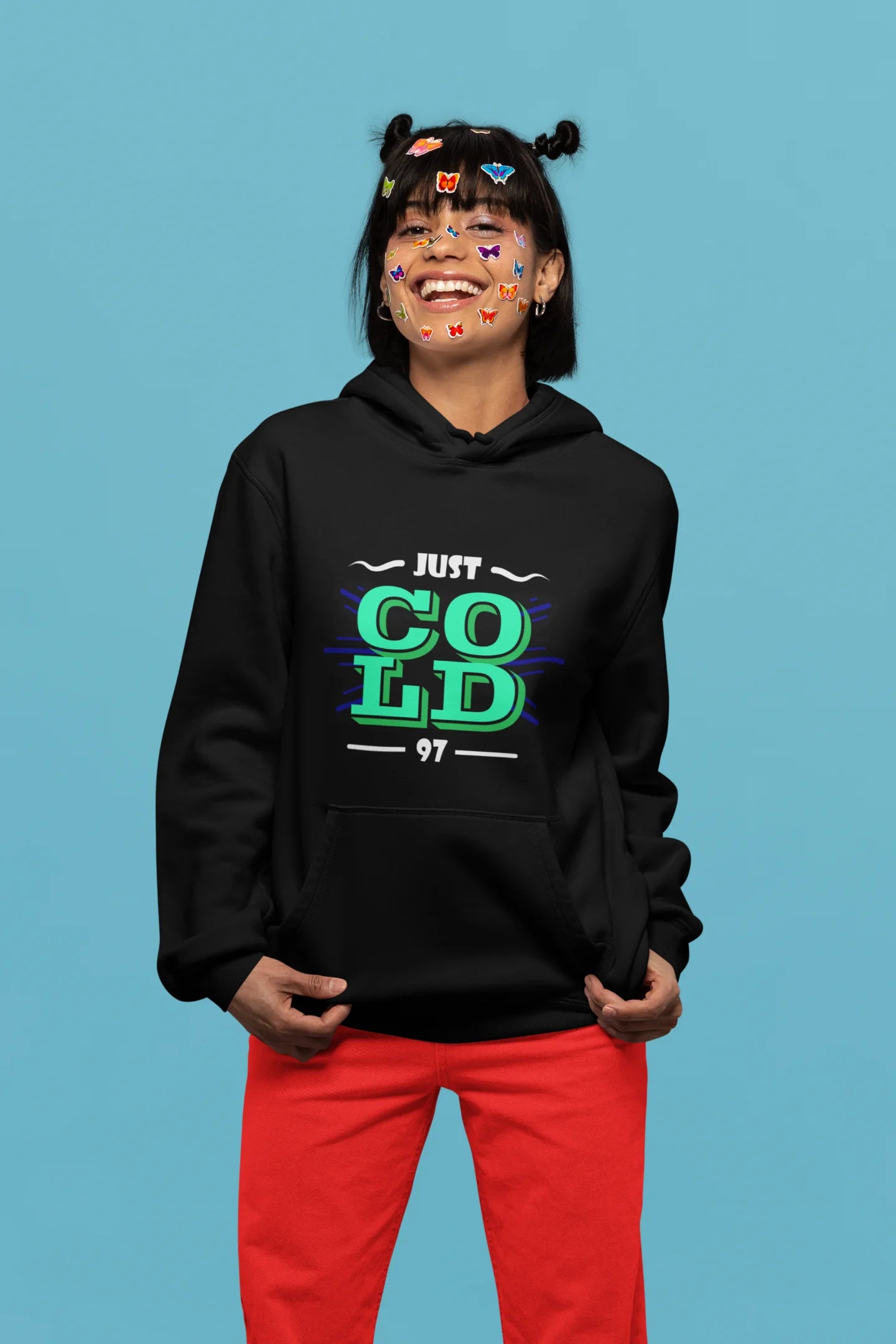 2nd front view of a female model wearing an black sweatshirt with the text "Just Cold" printed on it.