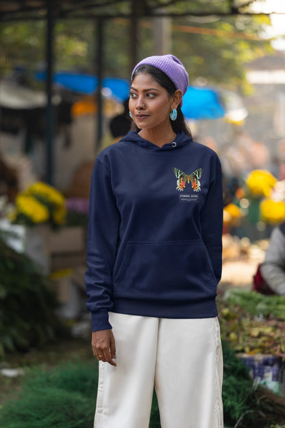 First front view of a female model wearing a navy blue hoodie with a glowing butterfly design, symbolizing the ethereal beauty of nature.