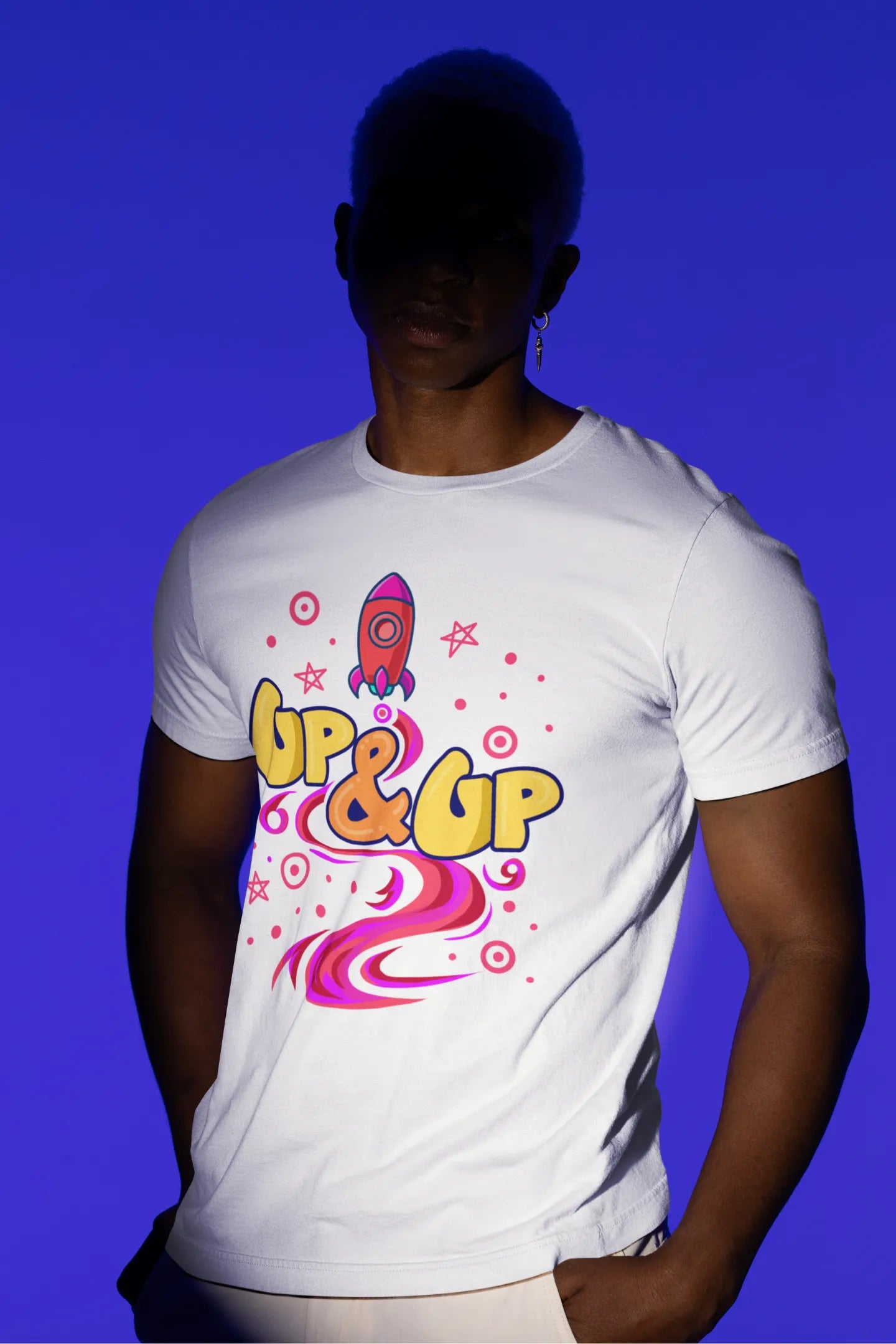 Third front view of a male model wearing an off-white oversized t-shirt with a rocket ship design and the text "Up & Up".