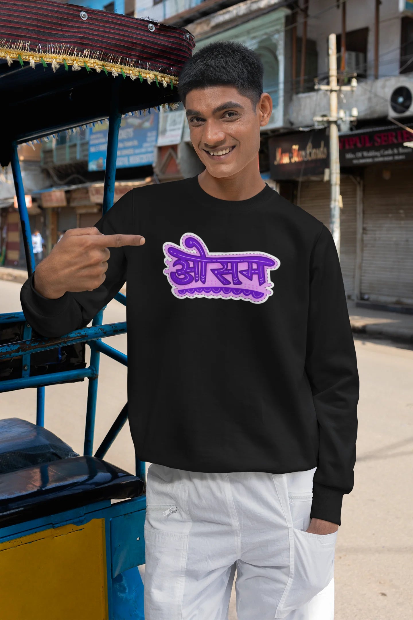 2nd front view of a male model wearing a black colored oversized graphic t-shirt featuring the word "awesome" in a Hindi script.