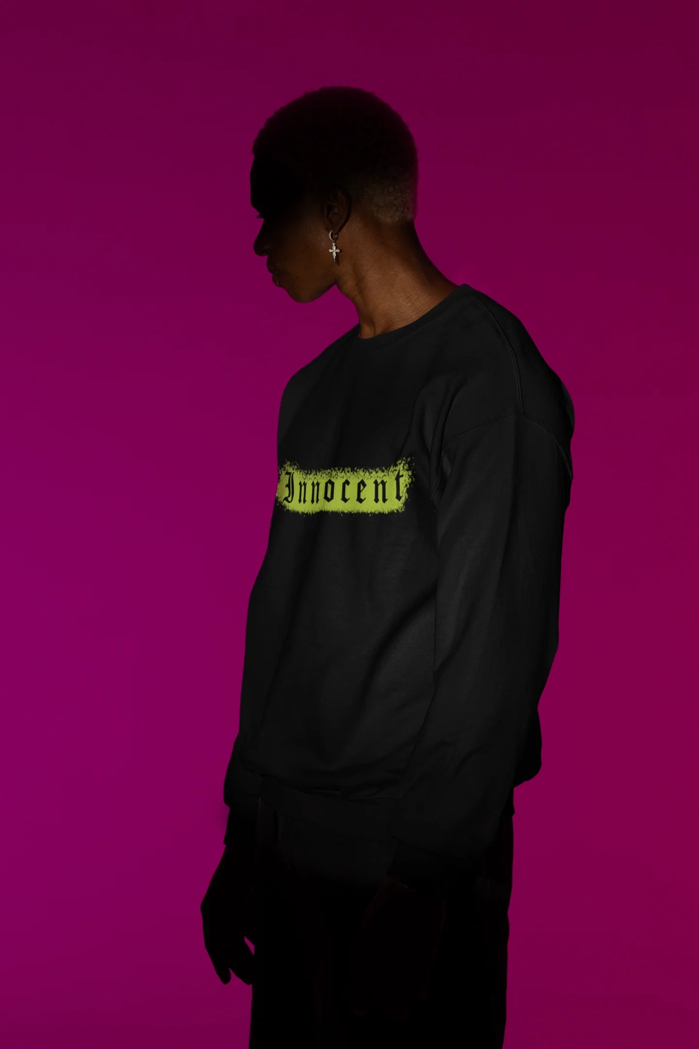 First front view of a male model wearing a black sweatshirt with a contrasting design of a cupid statue and brutalist elements.