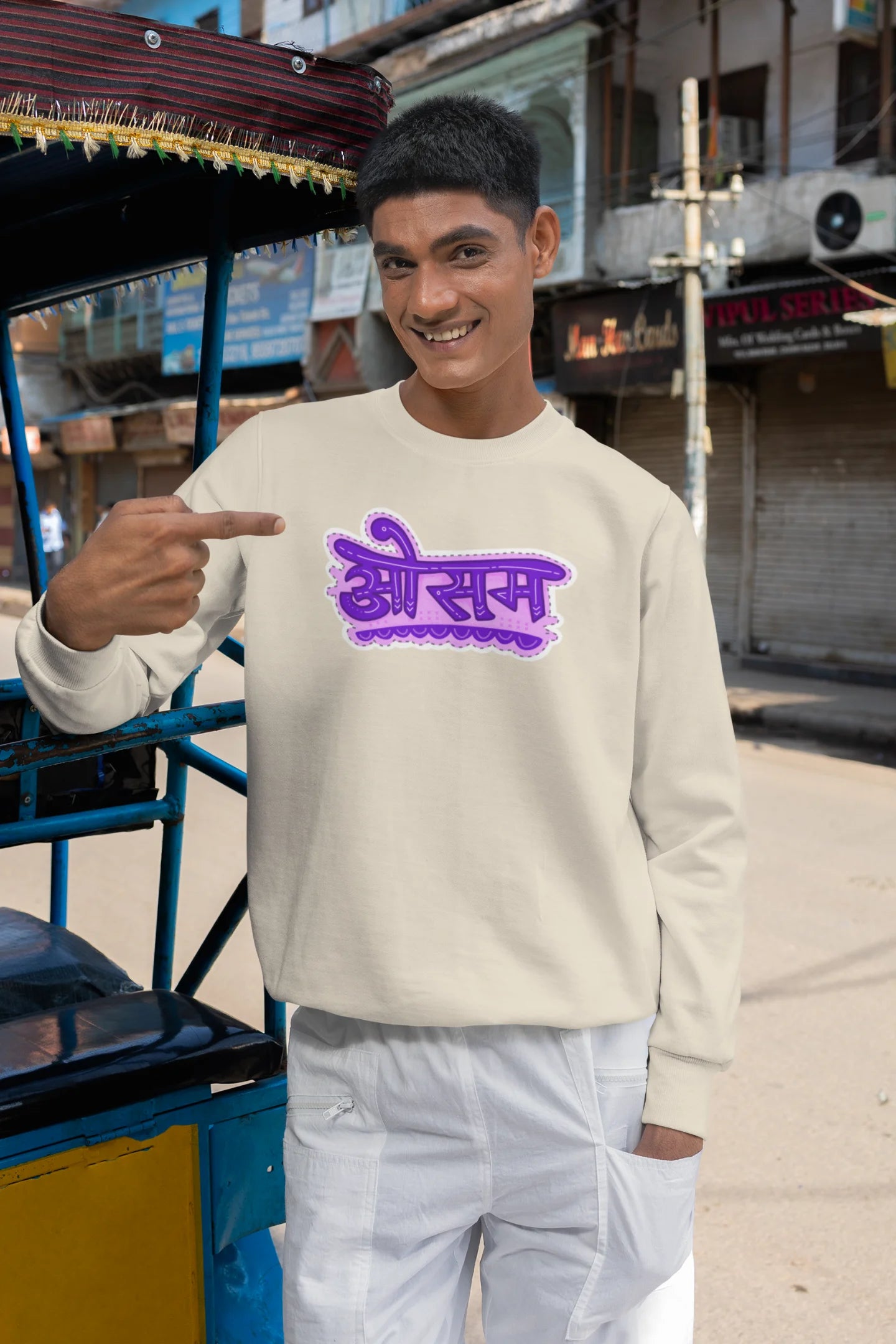 First front view of a male model wearing a cream colored oversized graphic t-shirt featuring the word "awesome" in a Hindi script.