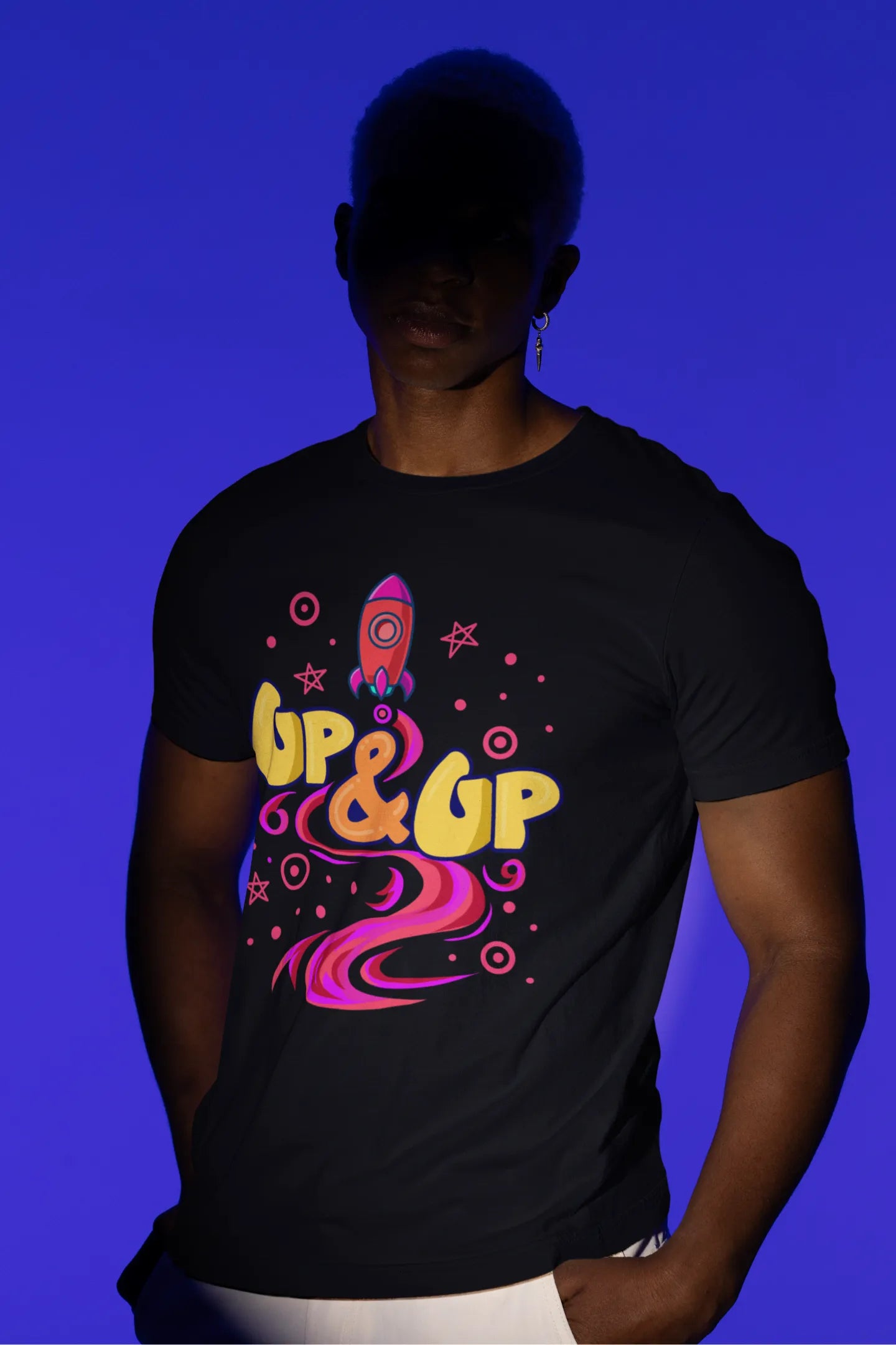 Third front view of a male model wearing an black oversized t-shirt with a rocket ship design and the text "Up & Up".
