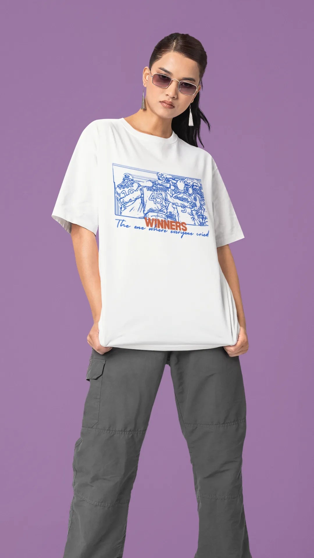 Side view of a female model wearing an of-white oversized t-shirt featuring a design of the Indian cricket team in a celebratory huddle with the text "Winners" above them. Ideal for Indian cricket fans commemorating their team's World Cup victory.