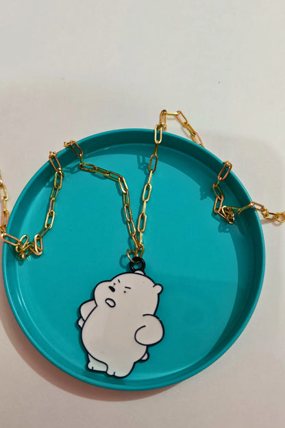 2nd view of a gold chain necklace with a small pendant shaped like Ice Bear