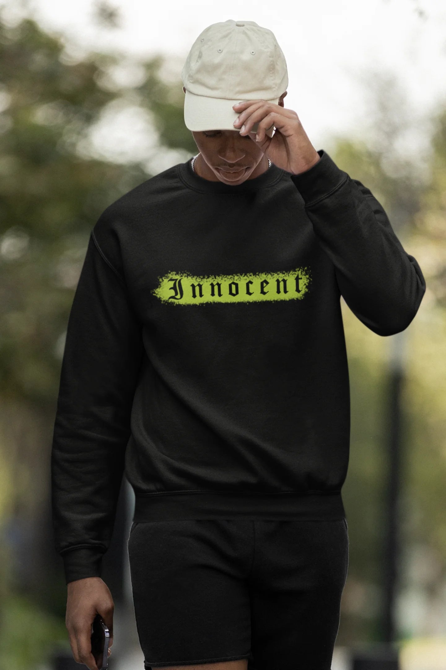 Third front view of a male model wearing a black sweatshirt with a contrasting design of a cupid statue and brutalist elements.