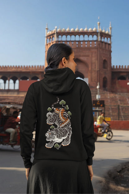 Back view of a female model wearing a black hoodie with a Japanese art style tiger design.