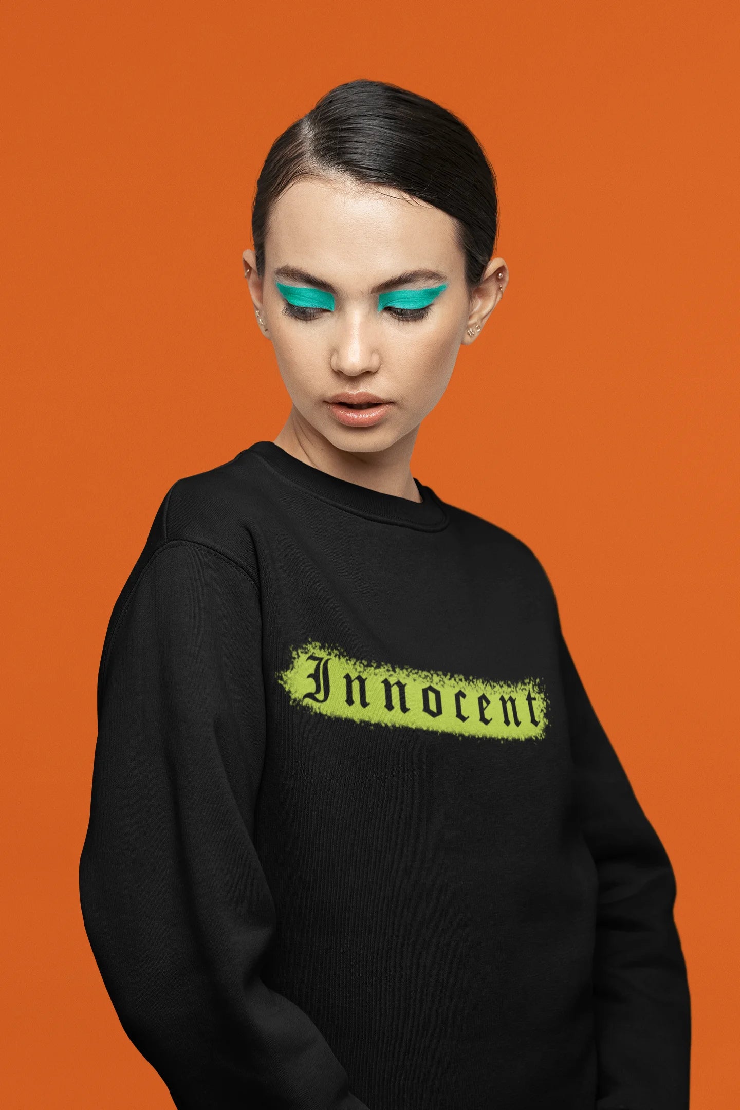 Third front view of a female model wearing a black sweatshirt with a contrasting design of a cupid statue and brutalist elements.