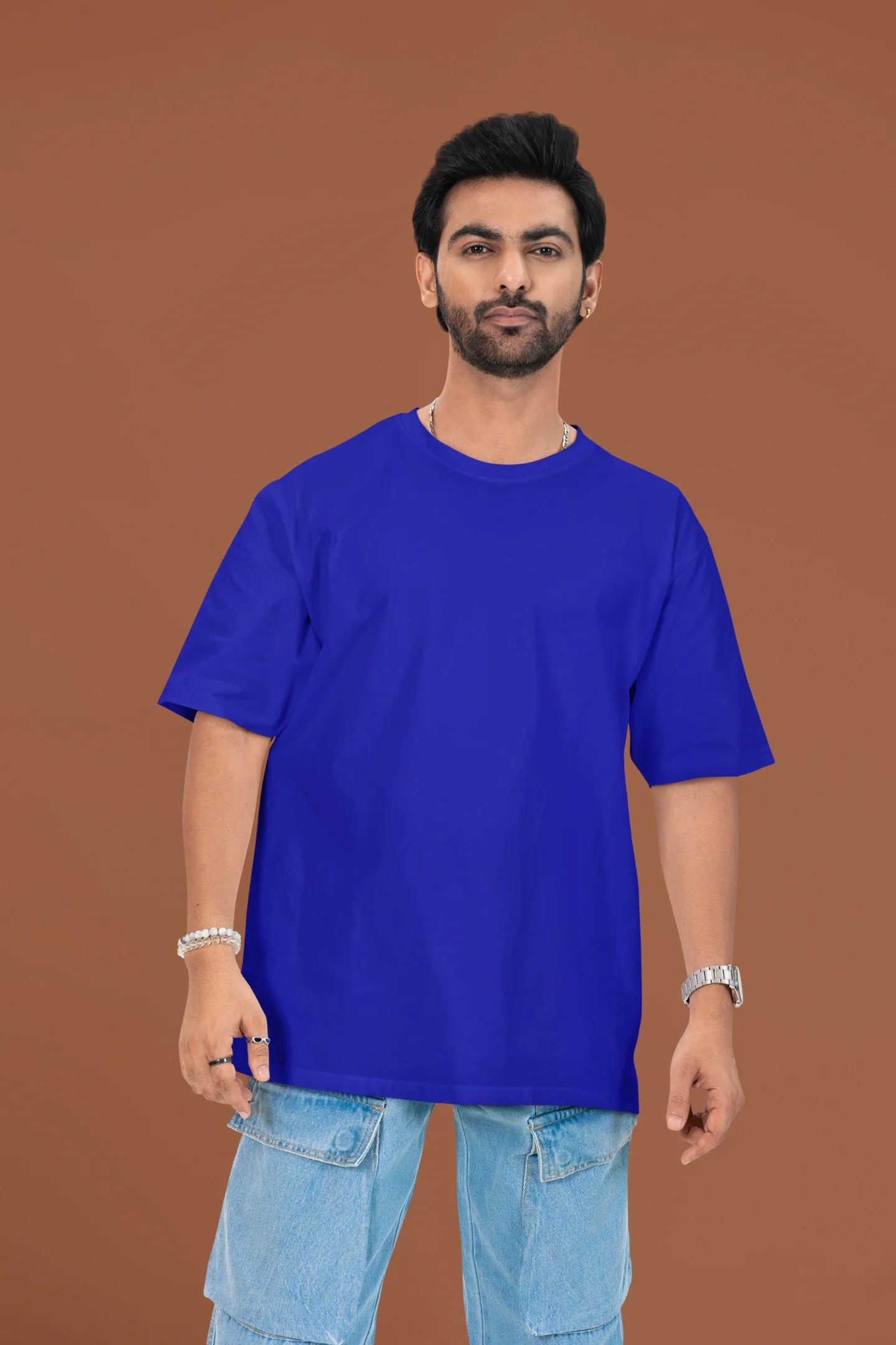 3rd front view of a male model wearing a royal blue oversized t-shirt featuring a beach at night with a starry sky above, inspired by Ed Sheeran's "Tenerife Sea."