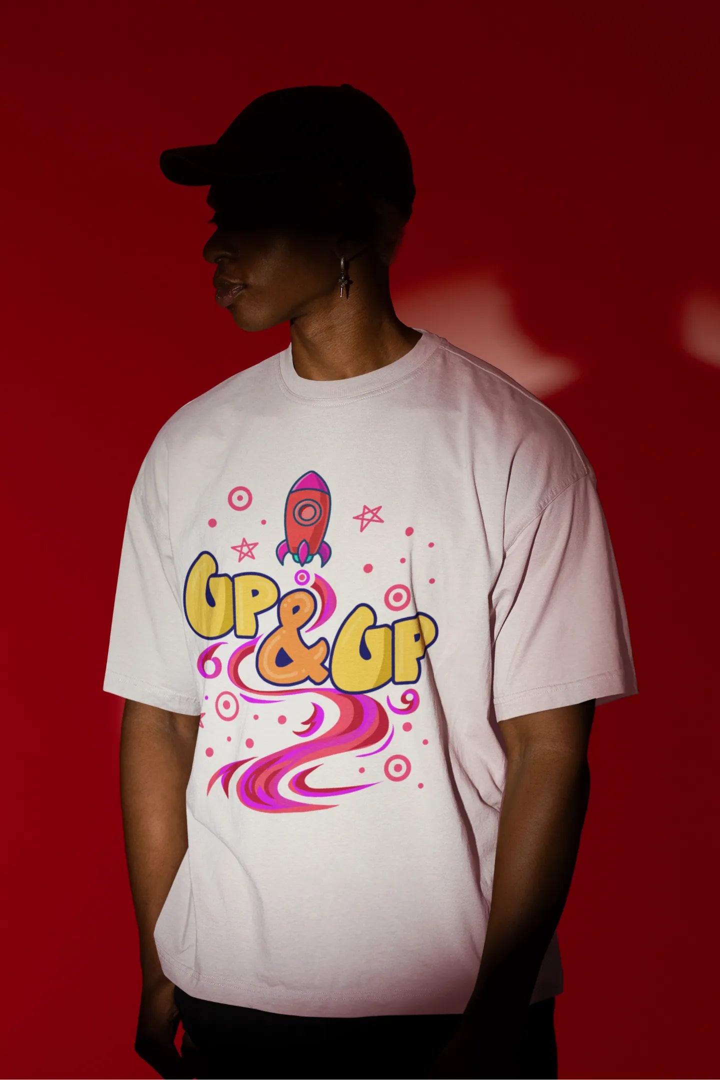 First front view of a male model wearing an off-white oversized t-shirt with a rocket ship design and the text "Up & Up".