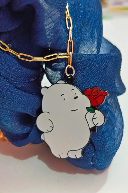 First view of a gold chain necklace with a small pendant of Ice Bear from a cartoon, holding a rose.
