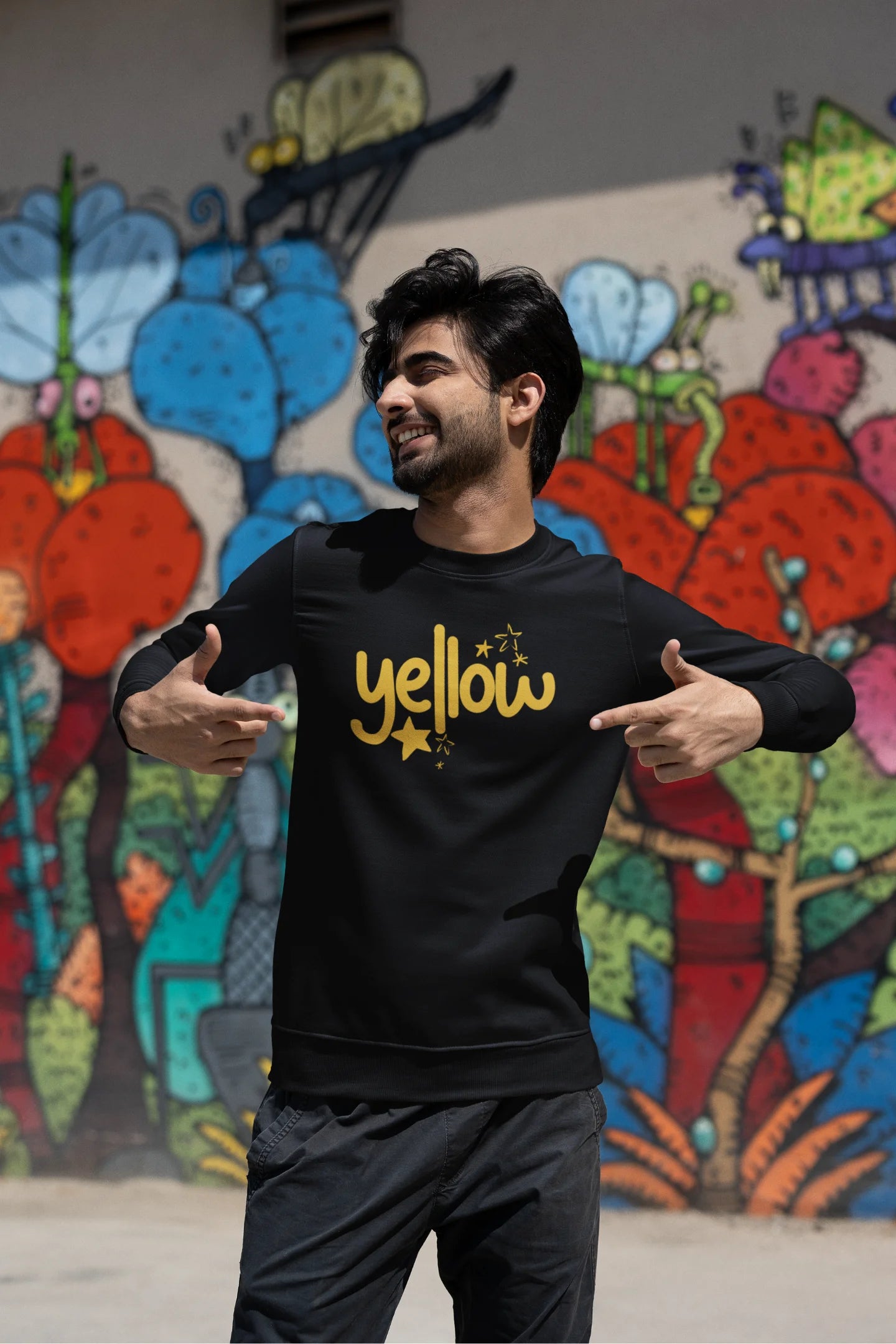 Third front view of a male model wearing a black sweatshirt with the "Yellow" album artwork by Coldplay.