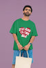 2nd front view of a male model wearing a forest green oversized t-shirt with the text 