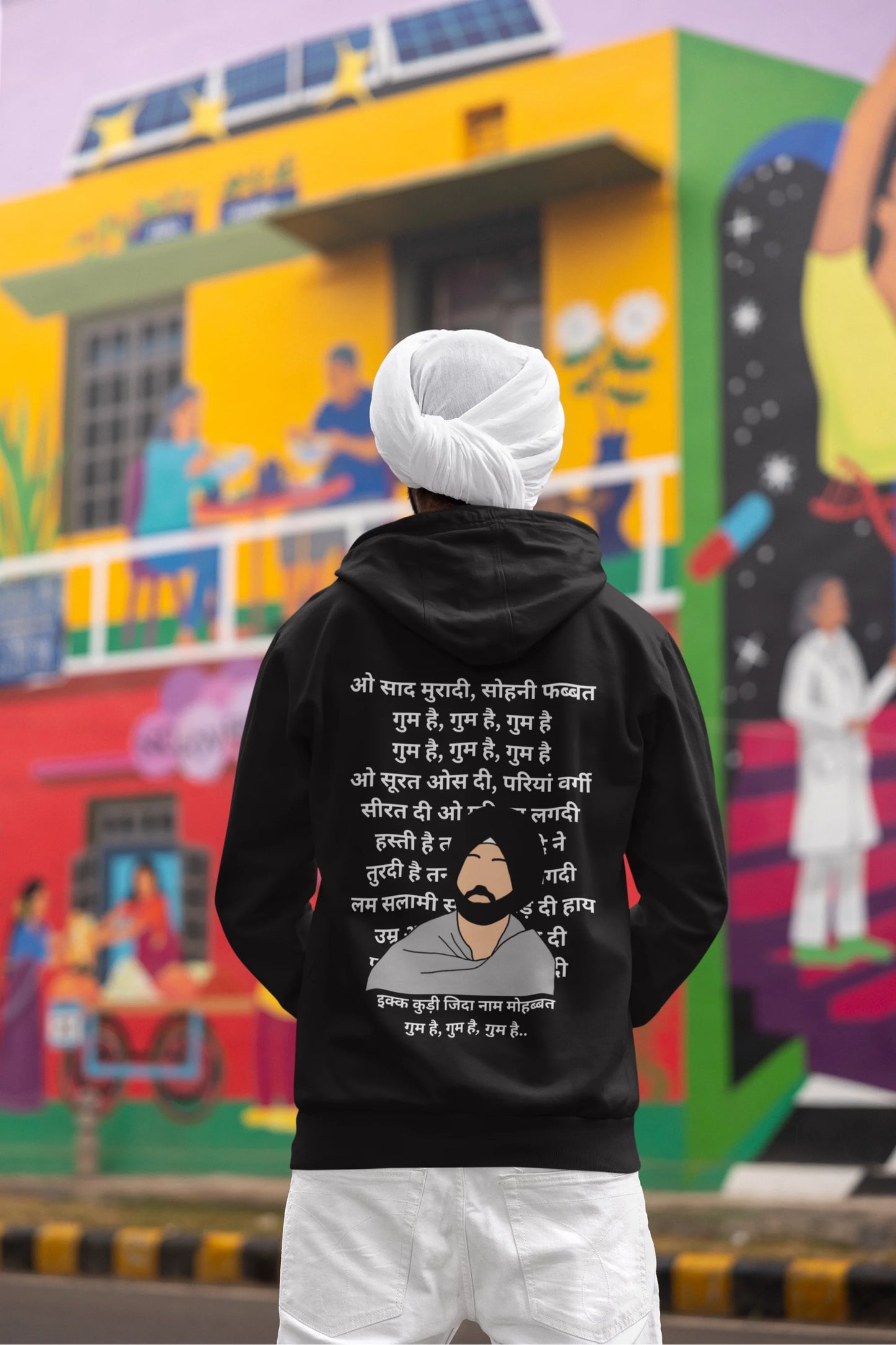 Back view of a male model wearing a black hoodie with a Diljit Dosanjh album cover and song titles.