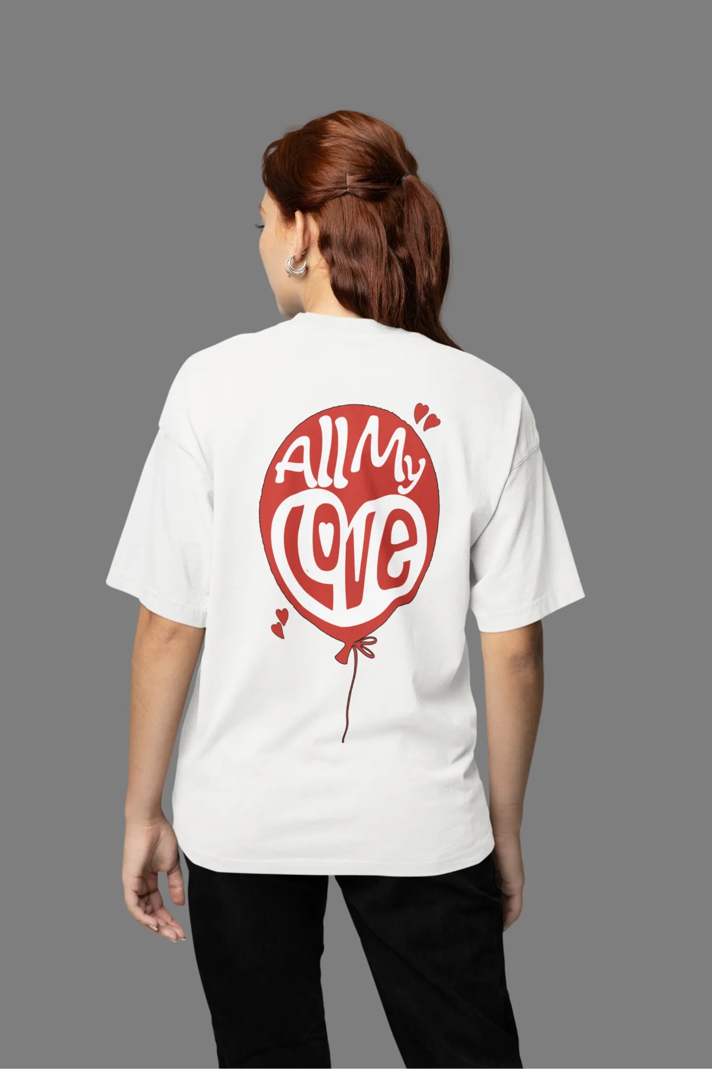 Back view of a female model wearing a off-white oversized t-shirt with a heart design and the text "All My Love".