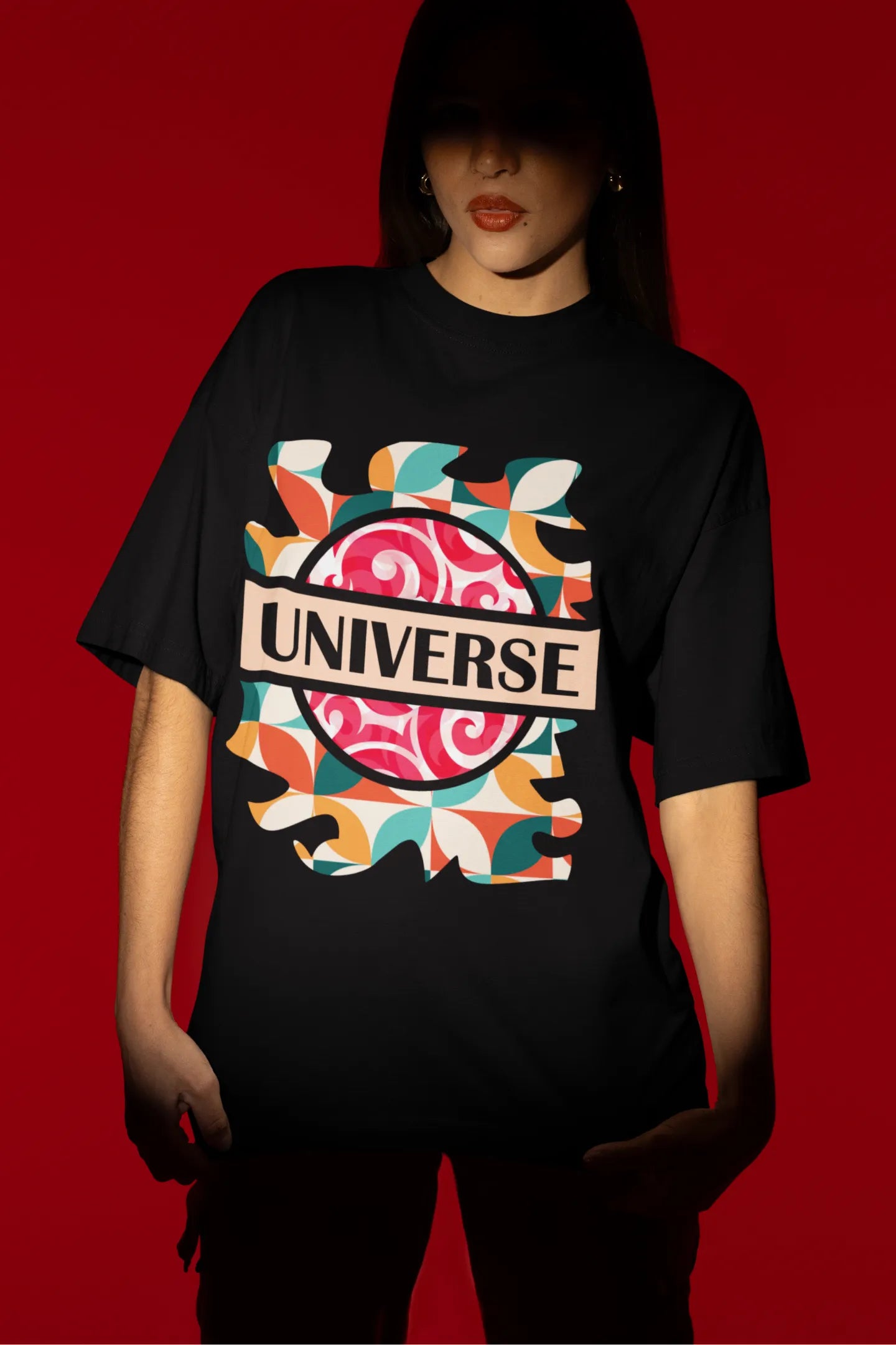First front view of a female model wearing an black oversized t-shirt with a cosmic Universe design inspired by Coldplay.