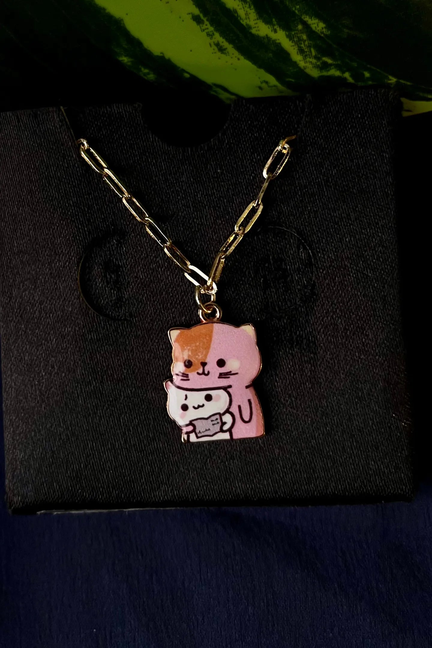 Fourth view of an anti tarnish gold chain necklace featuring a design of a mother cat and her kitten.