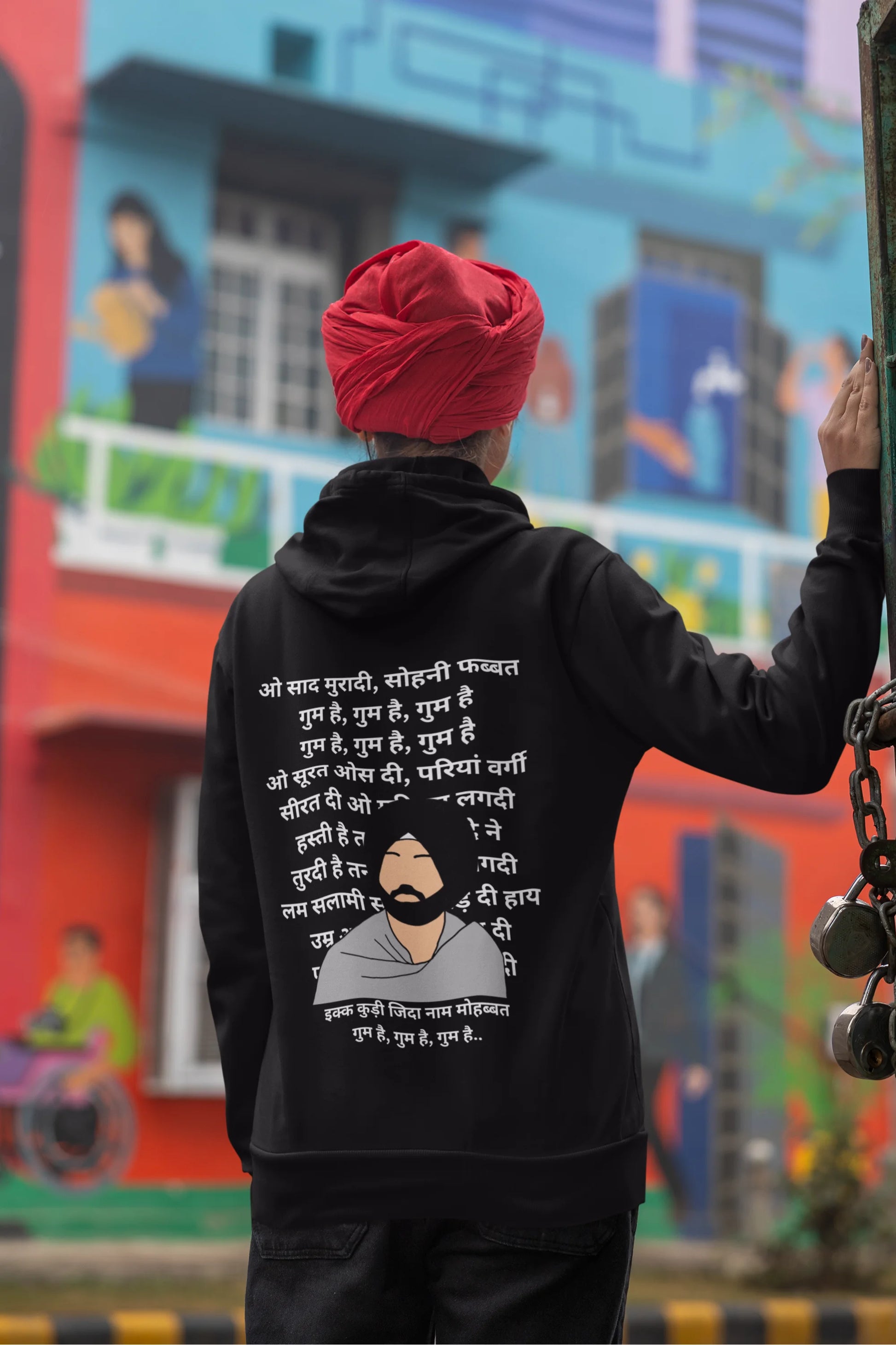 Back view of a female model wearing a black hoodie with a Diljit Dosanjh album cover and song titles.