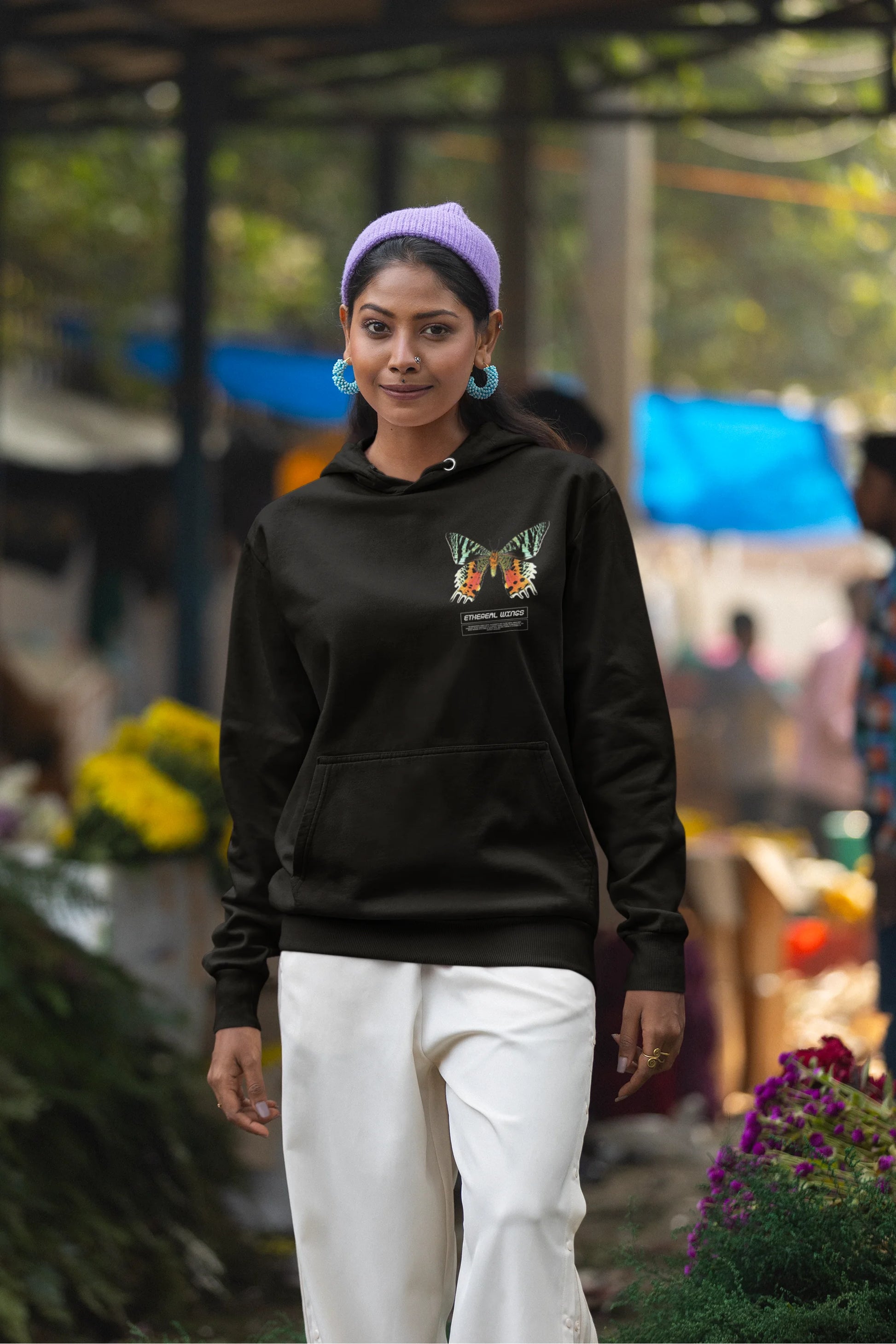 Second front view of a female model wearing a black hoodie with a glowing butterfly design, symbolizing the ethereal beauty of nature.