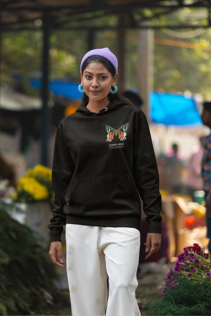 Second front view of a female model wearing a black hoodie with a glowing butterfly design, symbolizing the ethereal beauty of nature.