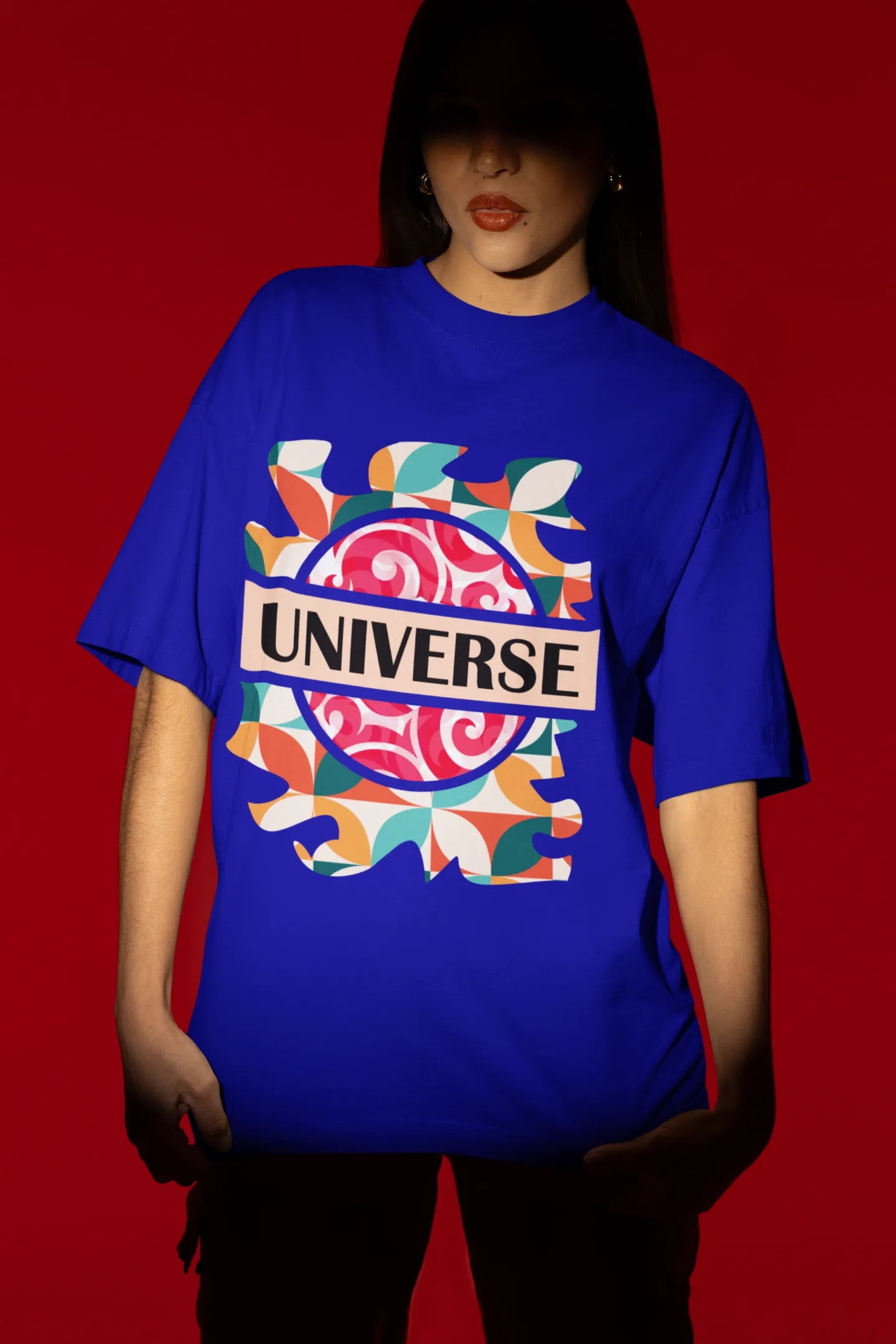 First front view of a female model wearing an royal blue oversized t-shirt with a cosmic Universe design inspired by Coldplay.