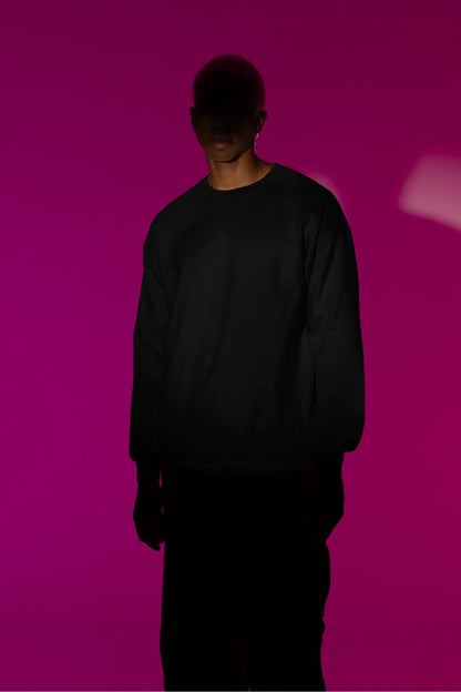 Third front view of male model wearing a black sweatshirt with a design of a cat dressed as a samurai, standing against a backdrop of waves and a rising sun.