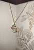 2nd view of a gold chain necklace with a small pendant depicting Shin Chan sleeping.