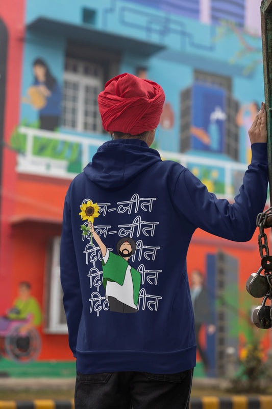 Back view of a female model wearing a royal blue hoodie with Diljit holding up a sunflower with the text "Dil Jeet" in the background.