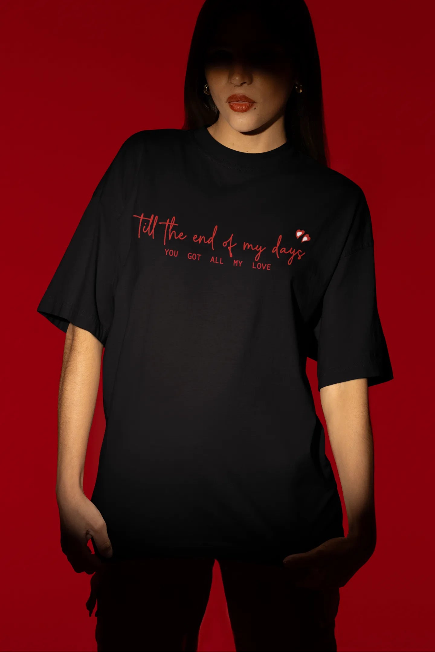 Third front view of a female model wearing a black oversized t-shirt with a heart design and the text "All My Love".